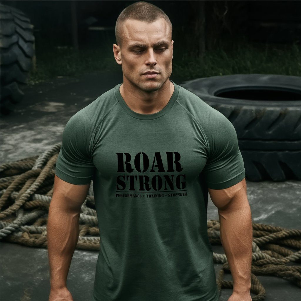 Hombre con camiseta militar ROAR STRONG junto a neumático de entrenamiento